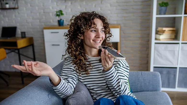Mujer sonriendo mientras habla por su iPhone