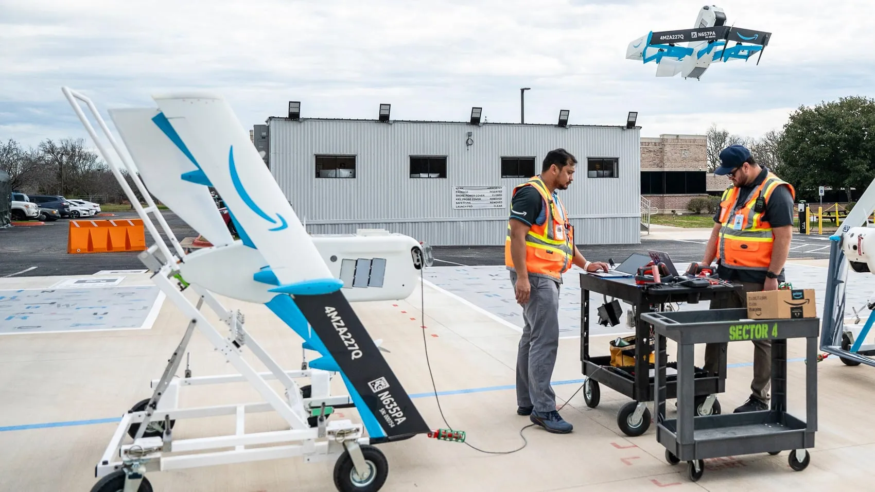 Dron de reparto Amazon MK30 sobre su plataforma de lanzamiento, con un segundo MK30 ascendiendo detrás