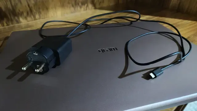 Cargador de 65 W y cable USB-C del LG gram Pro 17 sobre el portátil cerrado