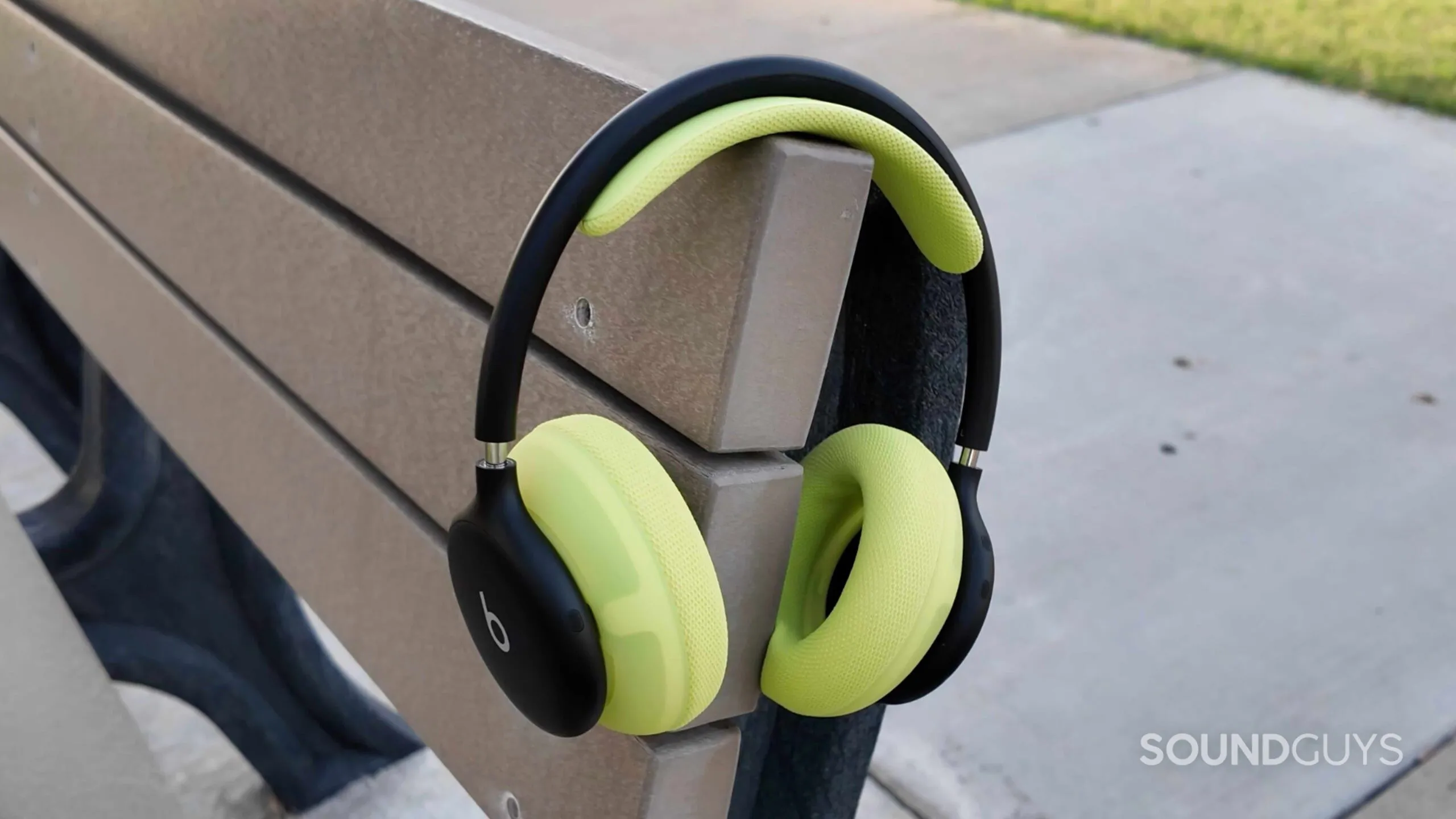 Los Beats 360 en negro y volt colgados de un banco