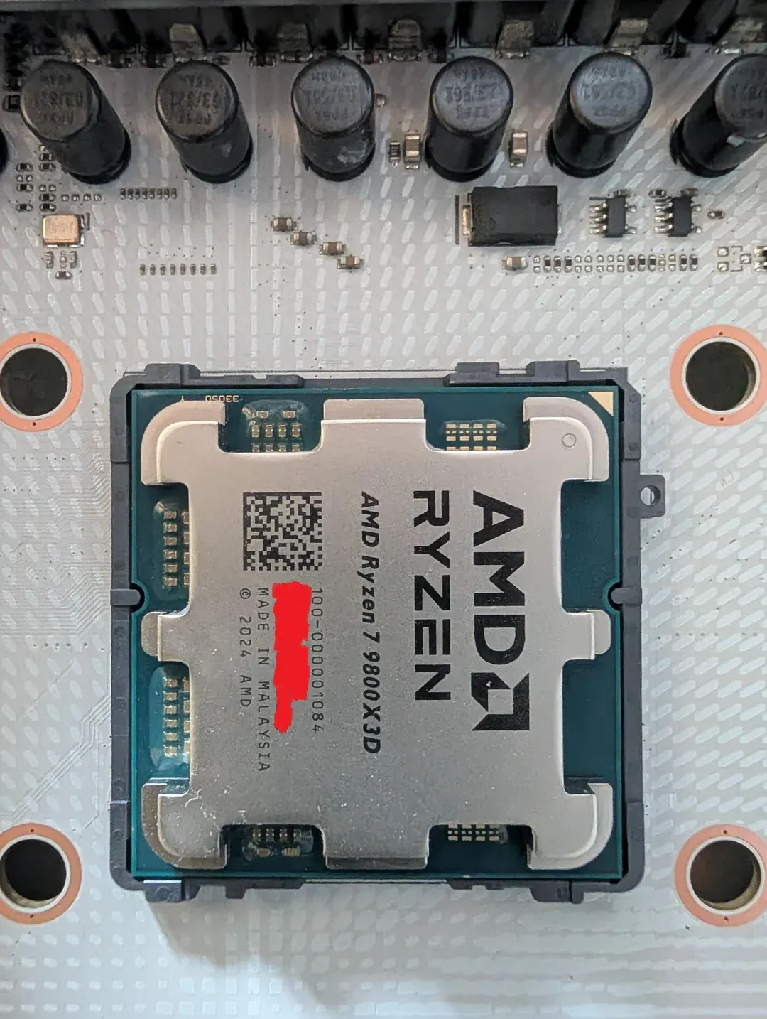 Procesador Ryzen 7 9800X3D montado en el zócalo AM5 de una placa base, con parte del número de serie oculto