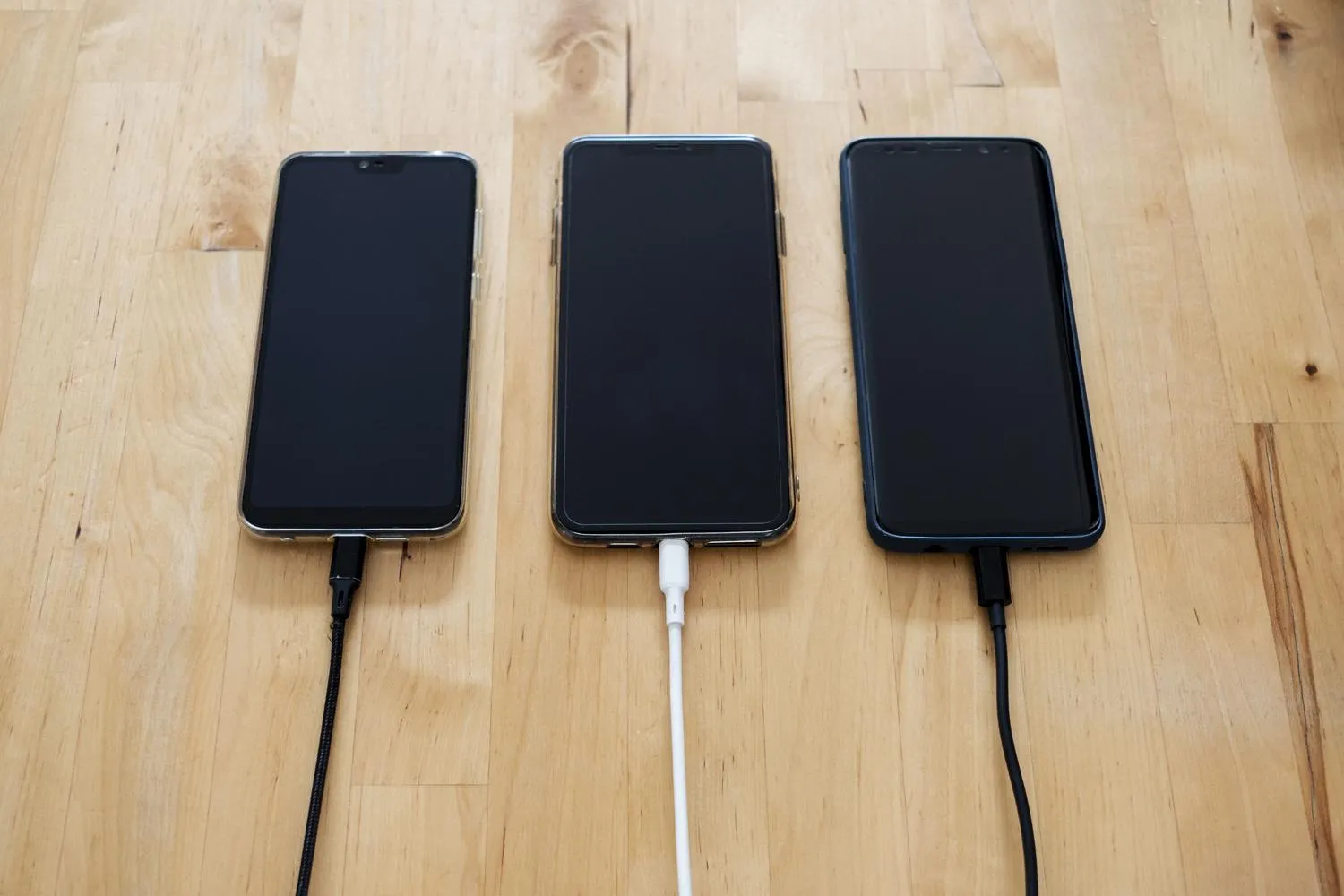 Varios smartphones cargándose a la vez sobre una superficie de madera