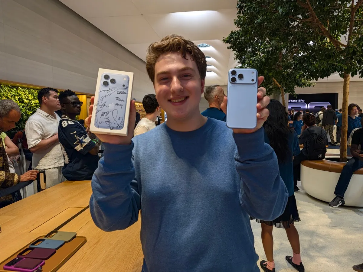 Un comprador muestra su iPhone 18 Pro Max en azul glaciar junto a la caja firmada