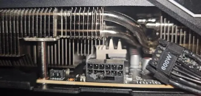 Conector de 12 pines al descubierto junto al disipador, con un cable etiquetado como 600W