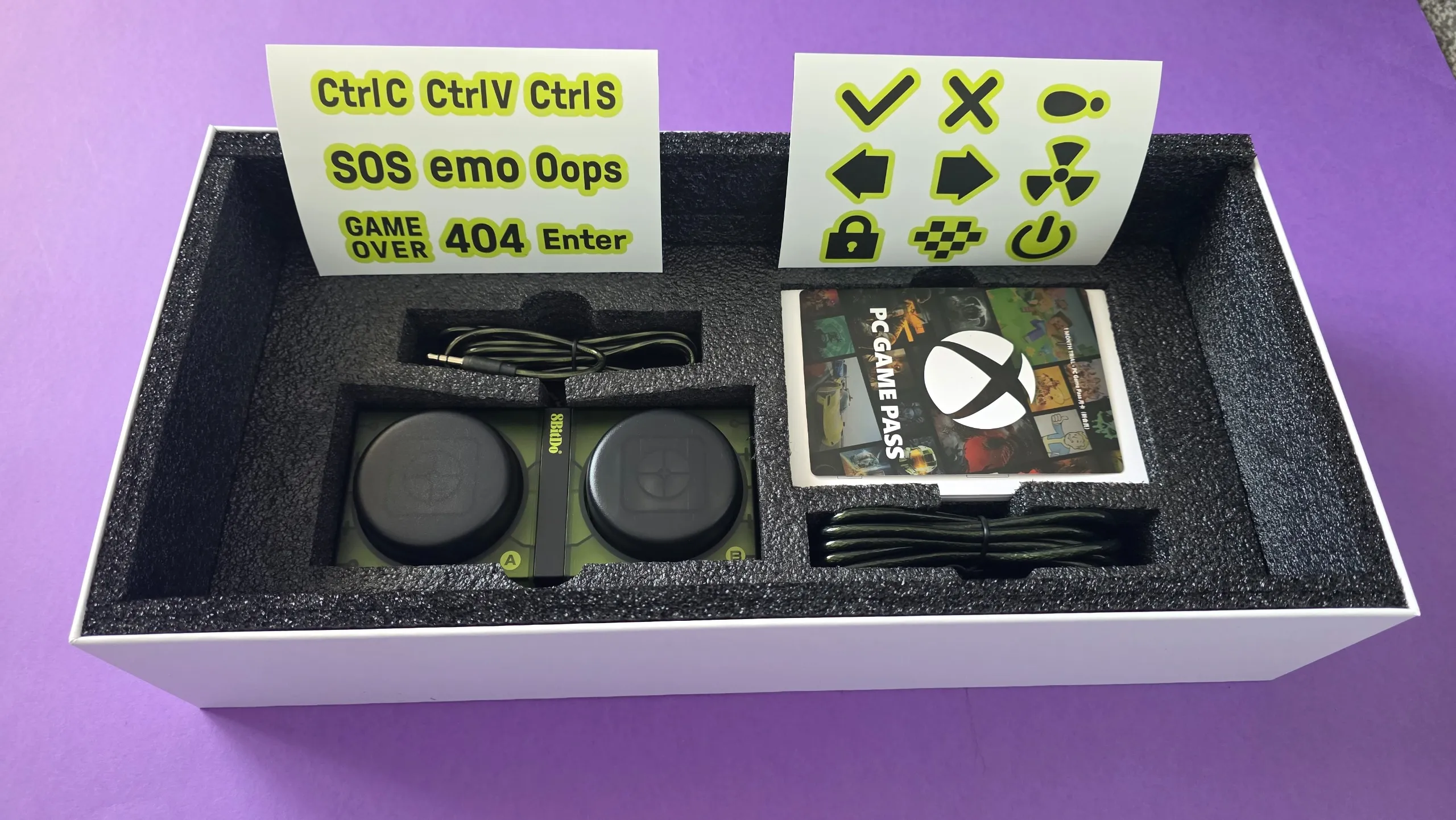 Caja abierta del teclado con pegatinas y el código de Xbox Game Pass