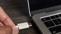 Persona conectando un cable USB-C a un portátil