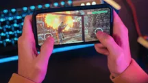 Persona jugando a un shooter de acción en un teléfono móvil