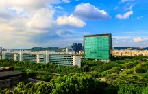 Huawei glass headquarters tower in Shenzhen rising above trees and campus buildings