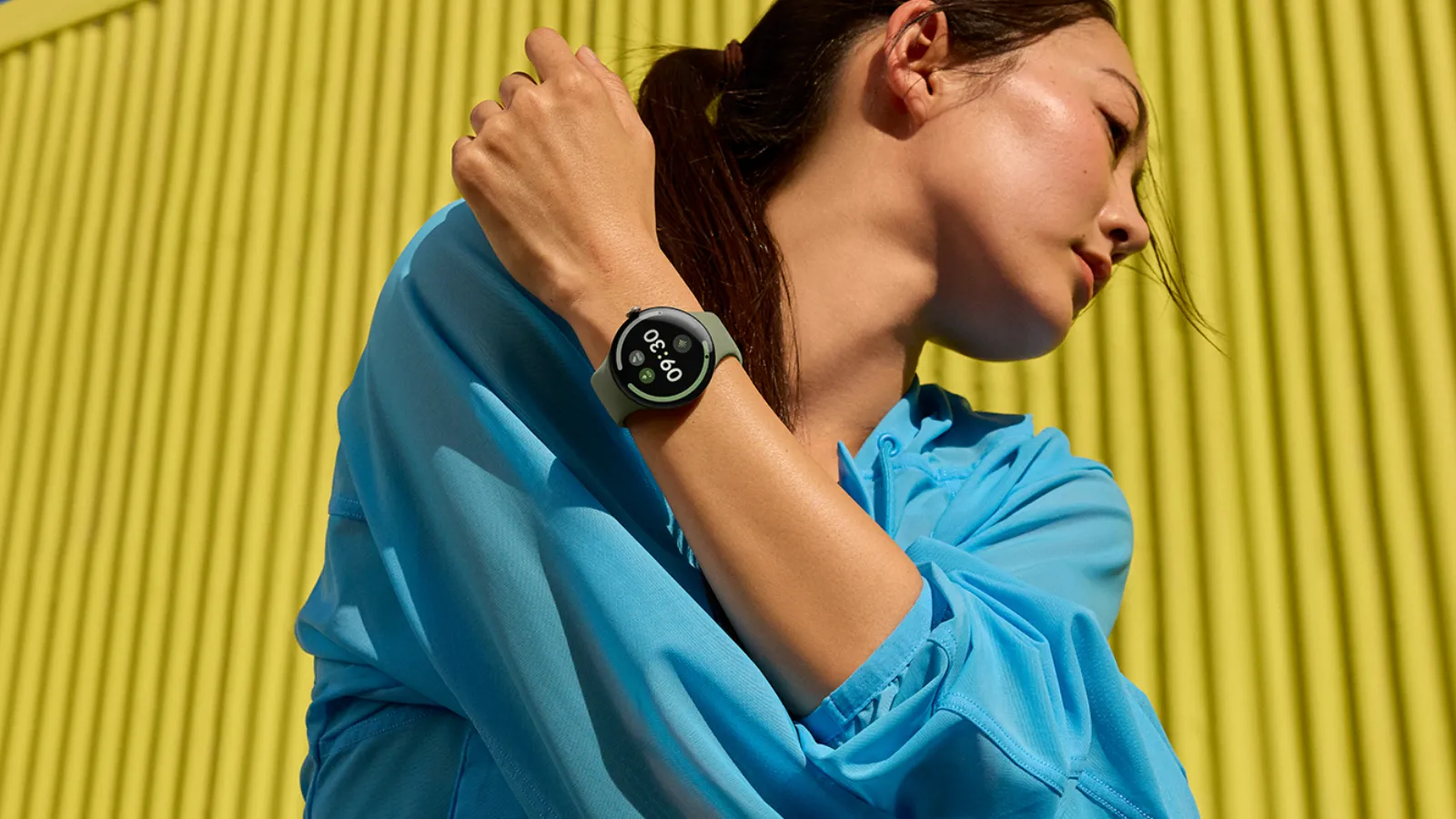 Reloj inteligente Google Pixel Watch 5 con esfera circular y correa deportiva en la muñeca de una persona