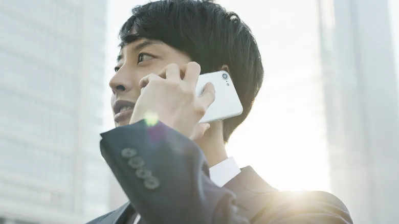 Un hombre atiende una llamada con un teléfono Android blanco