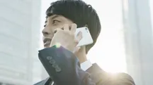 Un hombre atiende una llamada con un teléfono Android blanco