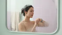 Persona con un reloj inteligente en la muñeca dentro de un cuarto de baño con vapor