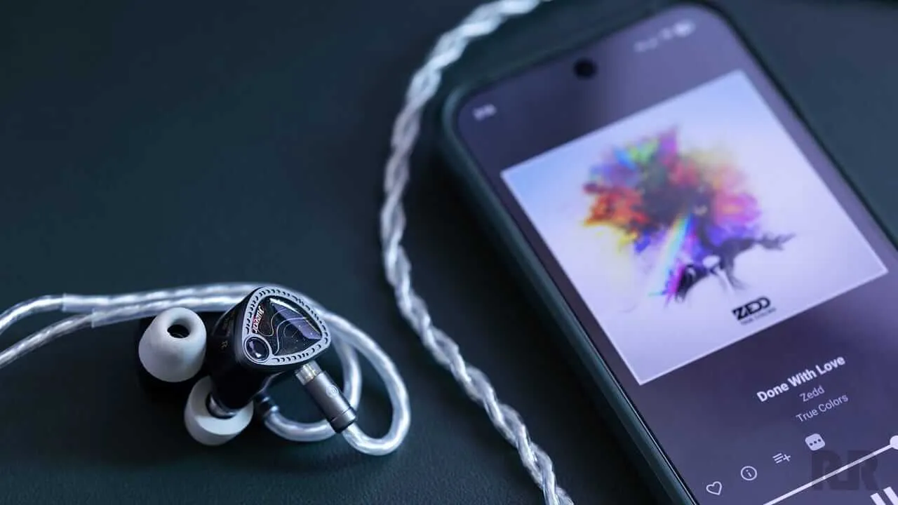 The Juzear Light Shuttle IEMs wired to a mobile phone