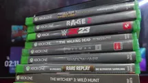 Pila de discos de Xbox junto a una consola de la marca