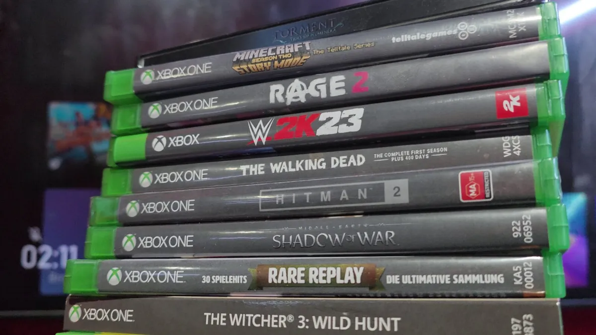 Pila de discos de Xbox junto a una consola de la marca