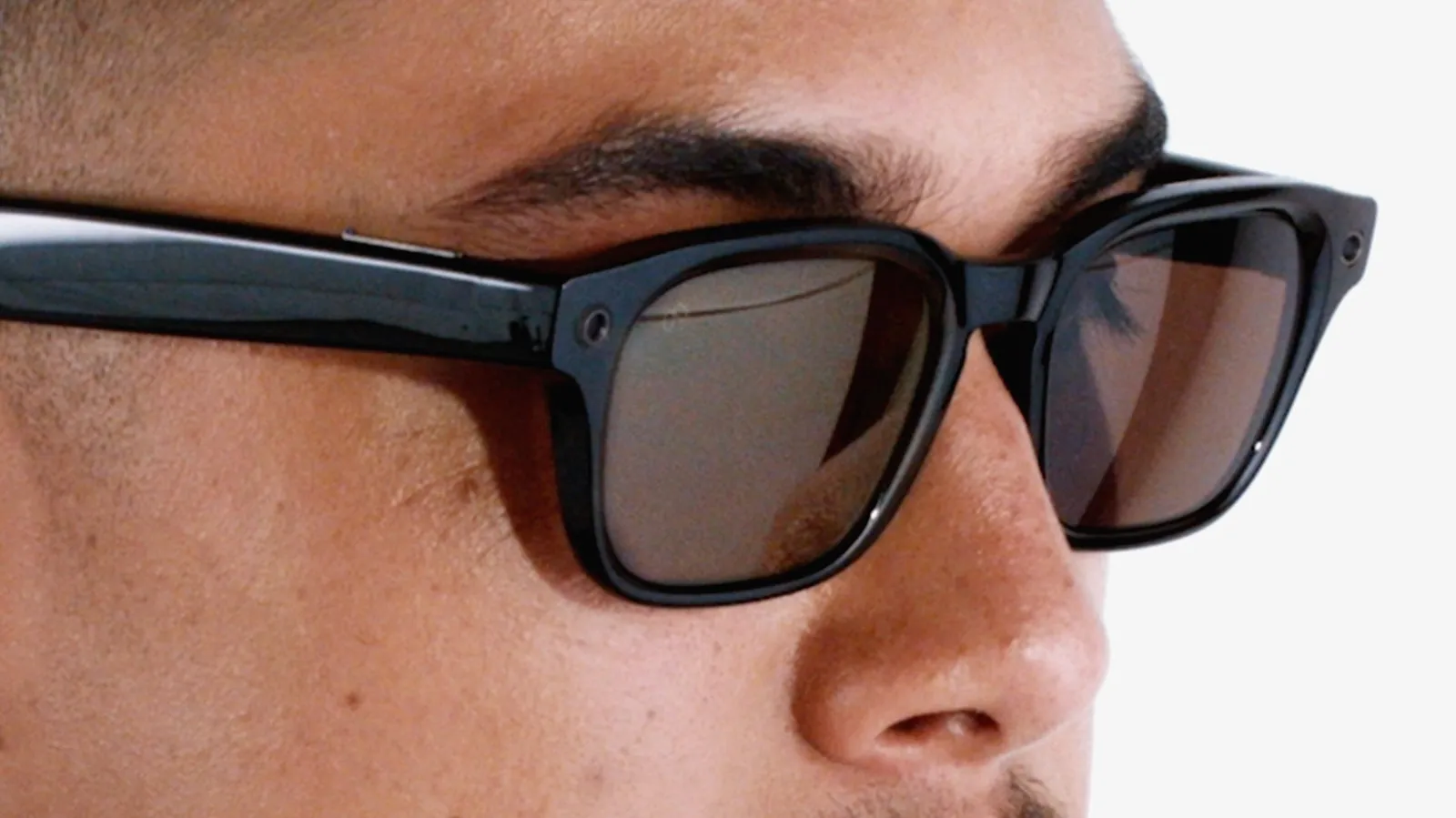 Primer plano de unas gafas inteligentes de Meta con montura negra sobre el rostro de un hombre