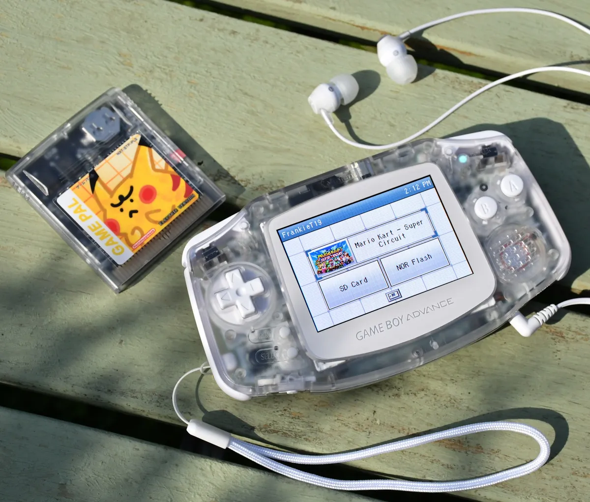 Game Boy Advance transparente mostrando el menú azul de DS Style junto a un cartucho de Pokémon
