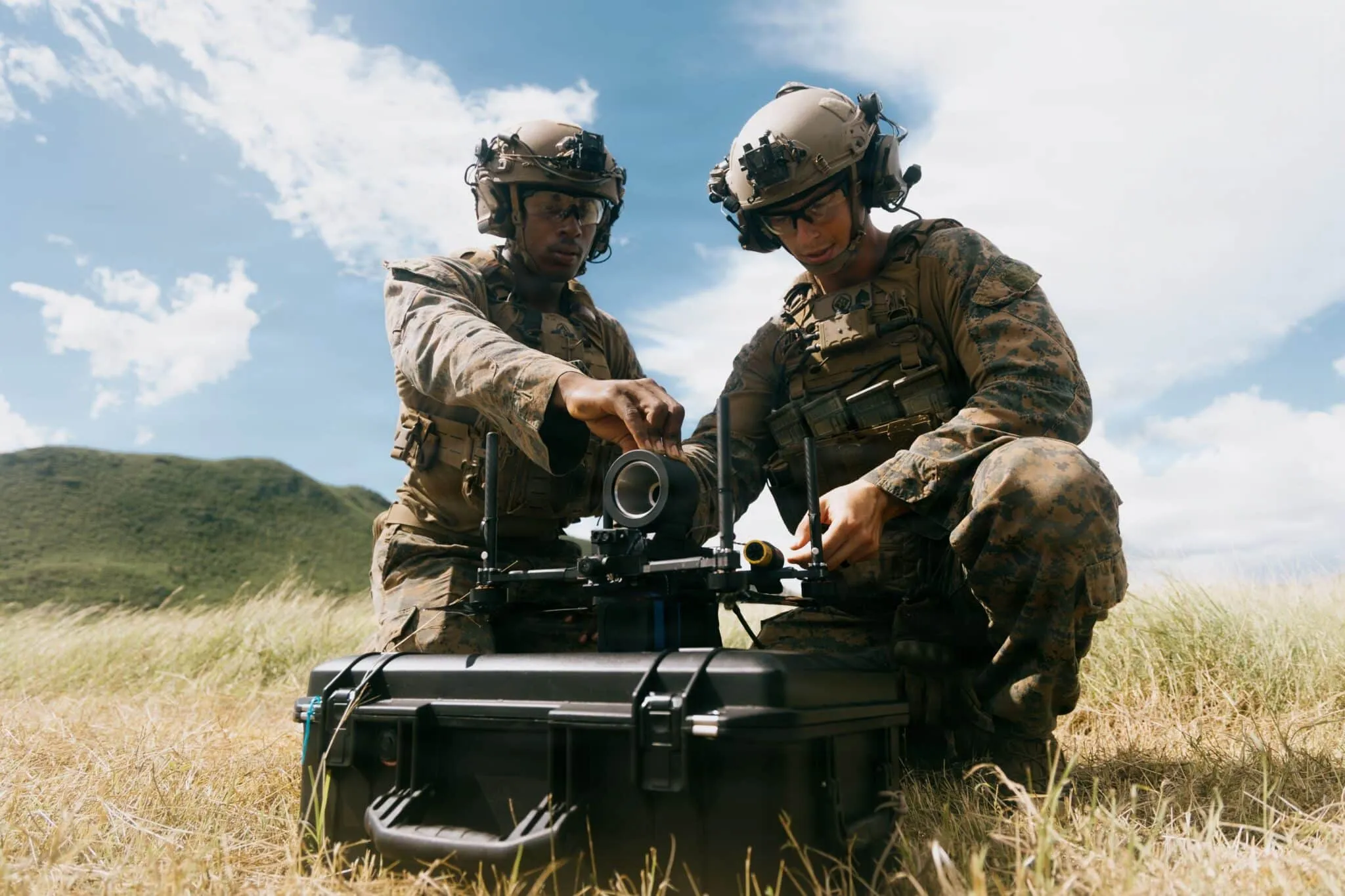 Two Marines load a simulated warhead onto a Neros Archer FPV drone fitted with a fiber-optic spool