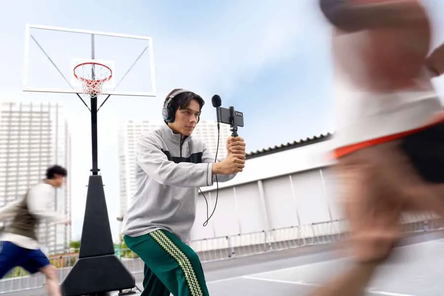 Creador grabando vídeo con el micrófono Sony ECM-AX10 montado en un smartphone, con auriculares puestos