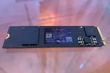 Unidad SSD WD Black SN7100 junto a su embalaje, de frente sobre fondo claro