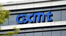 Logotipo azul de CXMT instalado sobre la fachada acristalada de un edificio corporativo