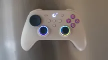 Grey GuliKit TT Pro with purple buttons and lit rings around the symmetrical sticks