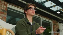 Persona con gafas inteligentes INMO Air 3 negras mirando al frente mientras sostiene un mando en la mano