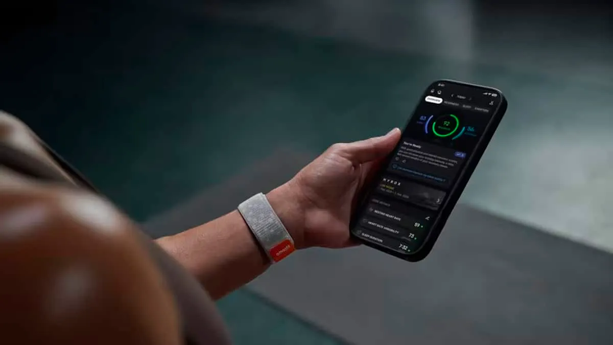 A person wearing the Amazfit Helio Strap on their wrist while checking the app on their phone