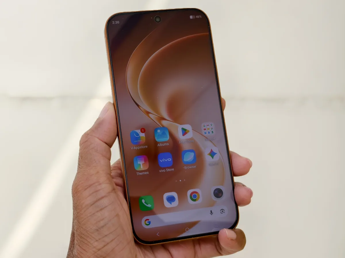 Teléfono Vivo V80 en color Sunrise Anthem sostenido en una mano con la pantalla encendida