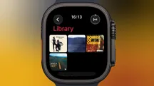 Pantalla de la biblioteca de la app Música en un Apple Watch, con varias portadas de álbumes en cuadrícula