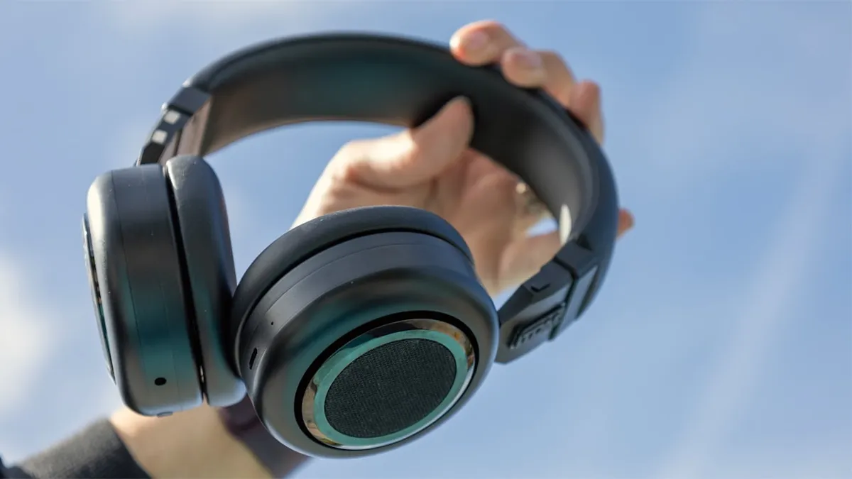 Auriculares TDM Neo en negro sostenidos con la mano
