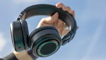 TDM Neo headphones in black held in one hand