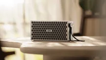Altavoz Loewe Neo con acabado claro situado en un salón junto a otros objetos