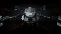 DJI Agras T100 agricultural drone seen from the front against a black background