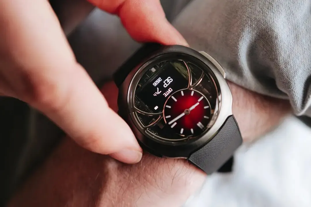 El H. Moser & Cie. Off-Grid en la muñeca, con esfera fumé roja, agujas y pantalla digital