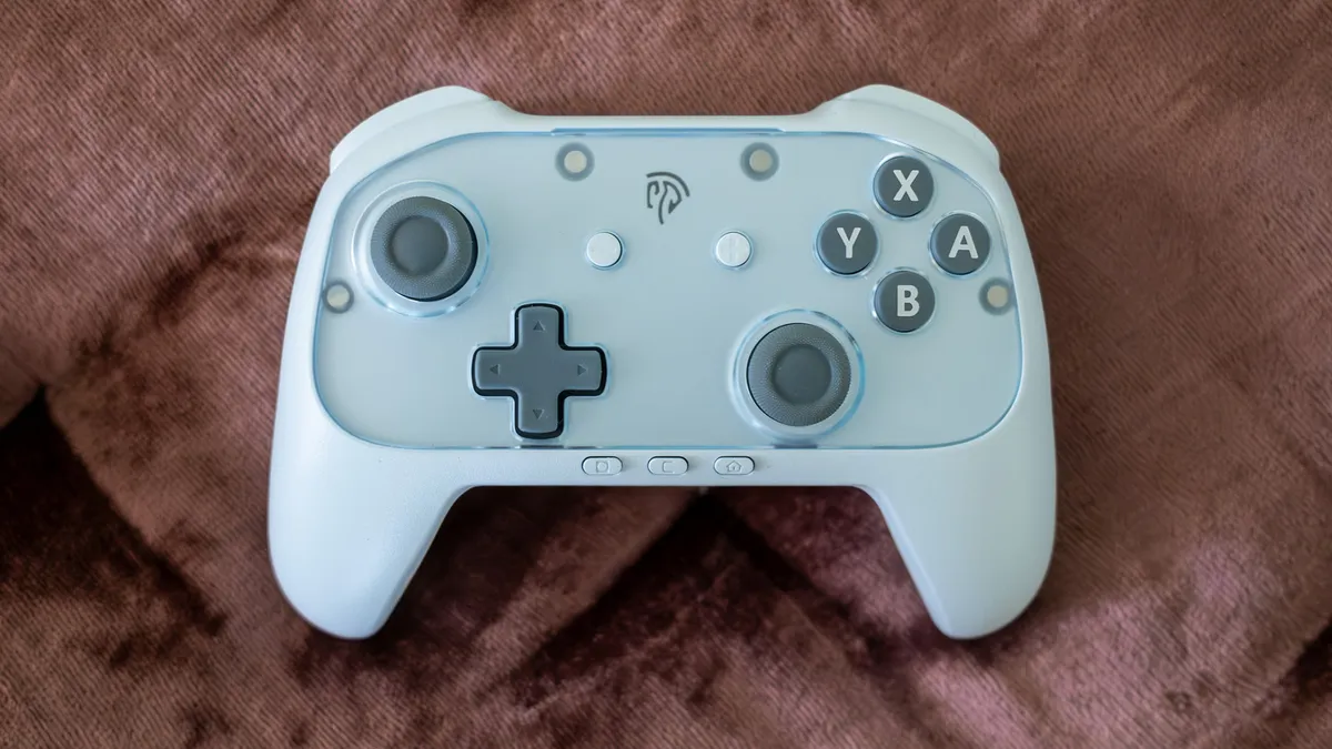 Light blue EasySMX S10 Lite controller with a translucent faceplate on brown fabric