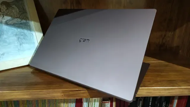 LG gram Pro 17 con la tapa cerrada y el logotipo gram, apoyado en una estantería de madera