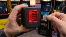 Ranura de monedas Insert Coin Cube junto a una pantalla con un emulador arcade