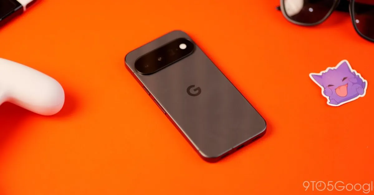 Móvil Google Pixel visto por detrás sobre una superficie naranja, junto a auriculares y gafas de sol