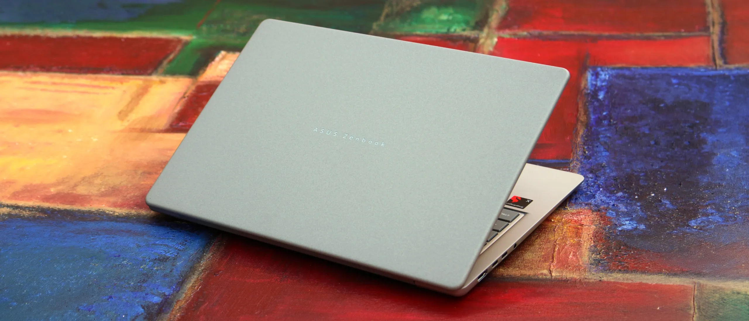 Portátil ASUS ZenBook 14 con acabado metálico sobre una superficie de madera