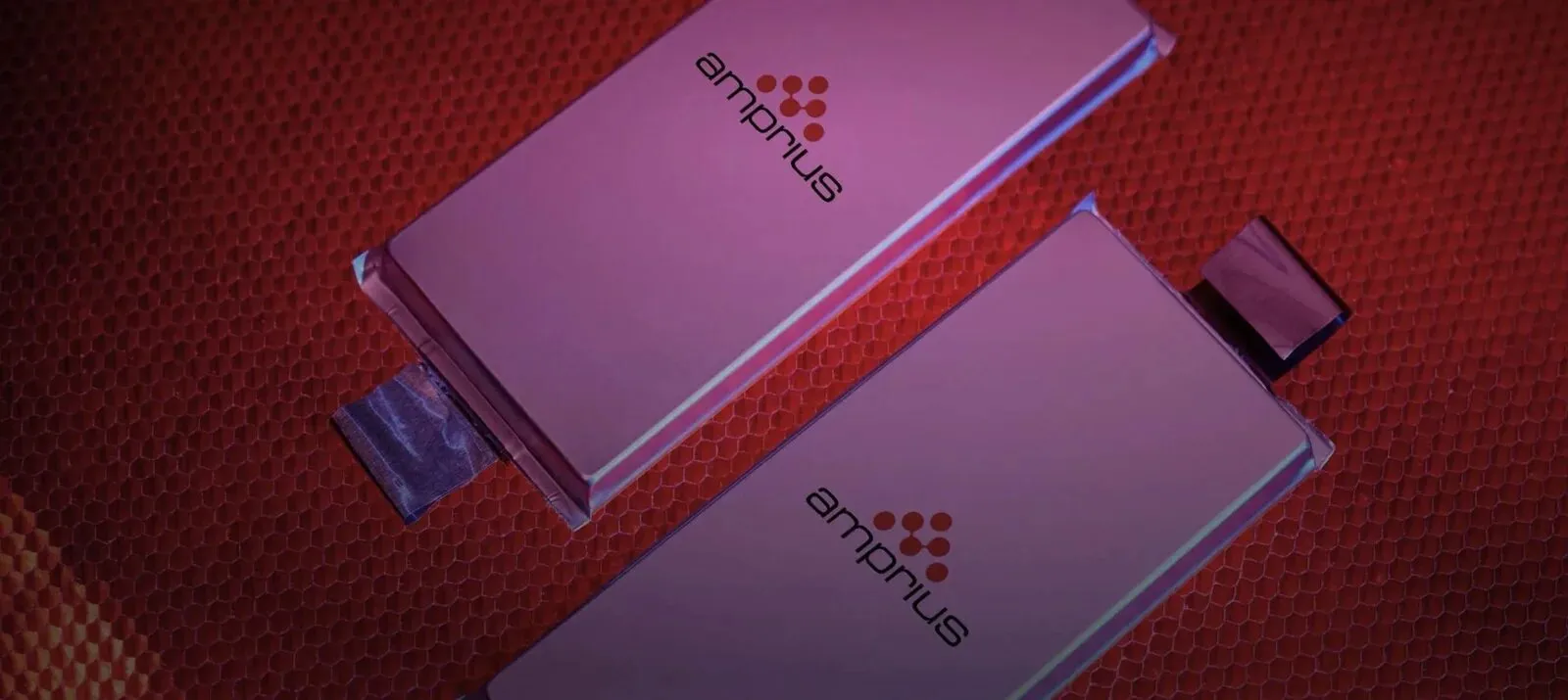 Two Amprius silicon-anode pouch cells on a red honeycomb-textured surface