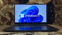 Portátil con el logotipo y el fondo de pantalla predeterminado de Windows 11