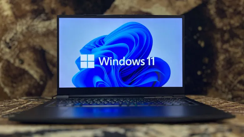 Portátil con el logotipo y el fondo de pantalla predeterminado de Windows 11