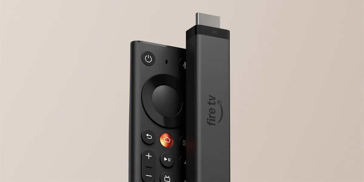 El nuevo Fire TV Stick 4K de Amazon junto a su mando rediseñado sobre un fondo beige