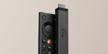 Amazon’s new Fire TV Stick 4K next to its redesigned remote on a beige background