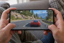 Manos sosteniendo un móvil con un juego de carreras; la mitad izquierda aparece etiquetada «off» y la derecha «on», con la imagen más nítida