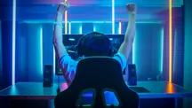 Jugador de PC sonriendo frente a un equipo de sobremesa con iluminación RGB