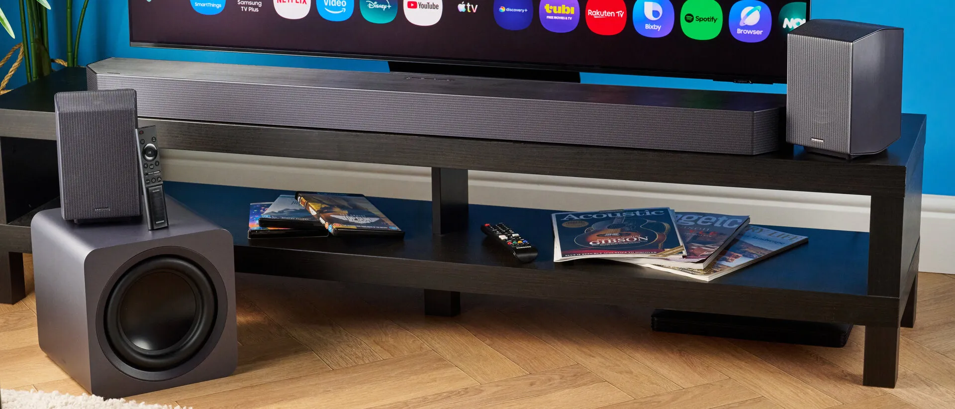 Barra Samsung Q990H bajo un televisor, con subwoofer y dos altavoces traseros