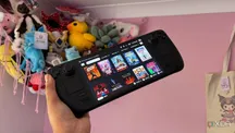 Consola Steam Deck mostrando el menú de juegos con varios peluches al fondo