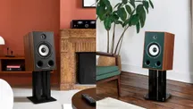 Dos altavoces Triangle Borea BR05 con frontales oscuro y verde colocados sobre soportes negros en un salón